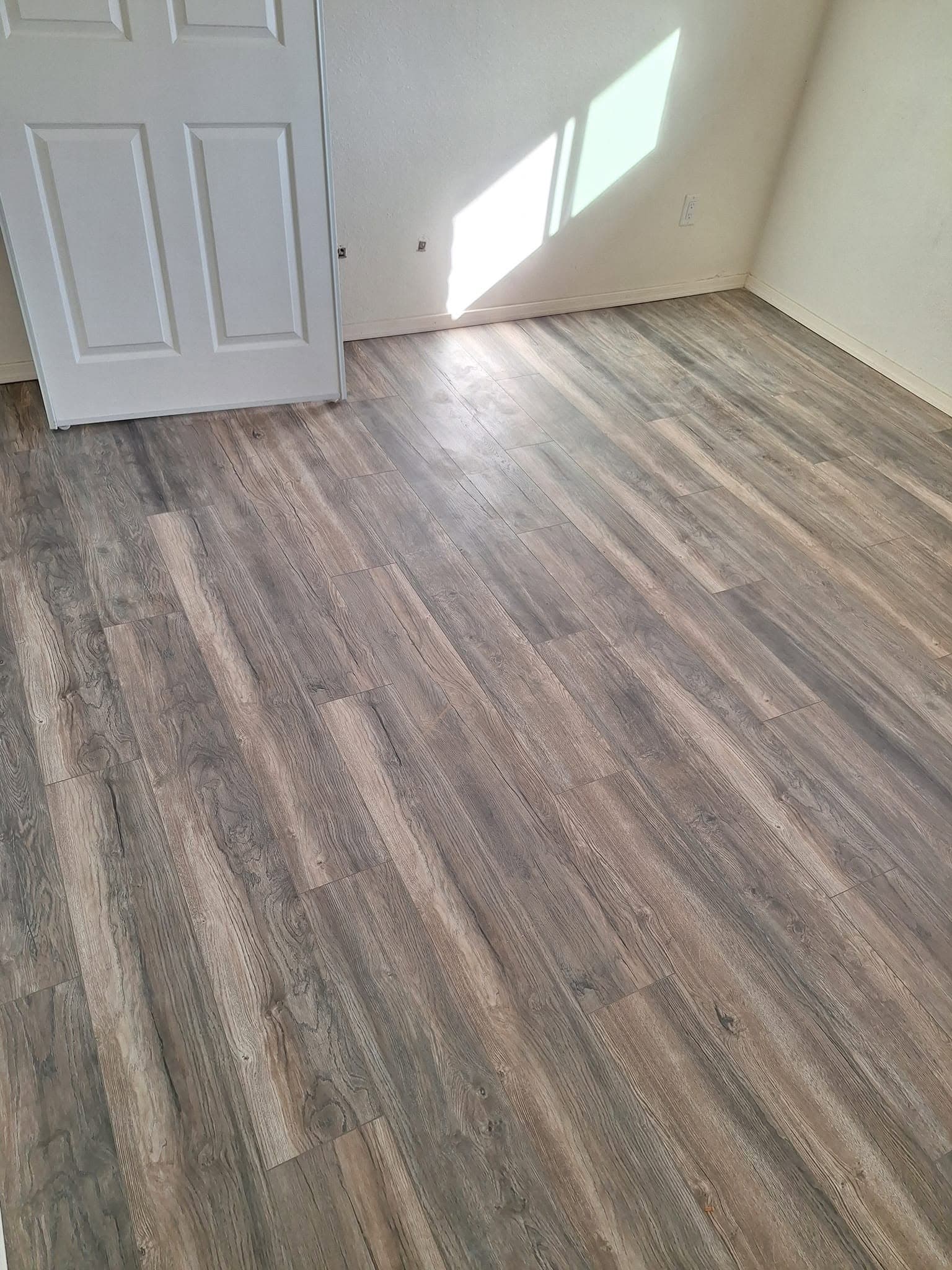 After: bedroom with finished wood-look plank flooring