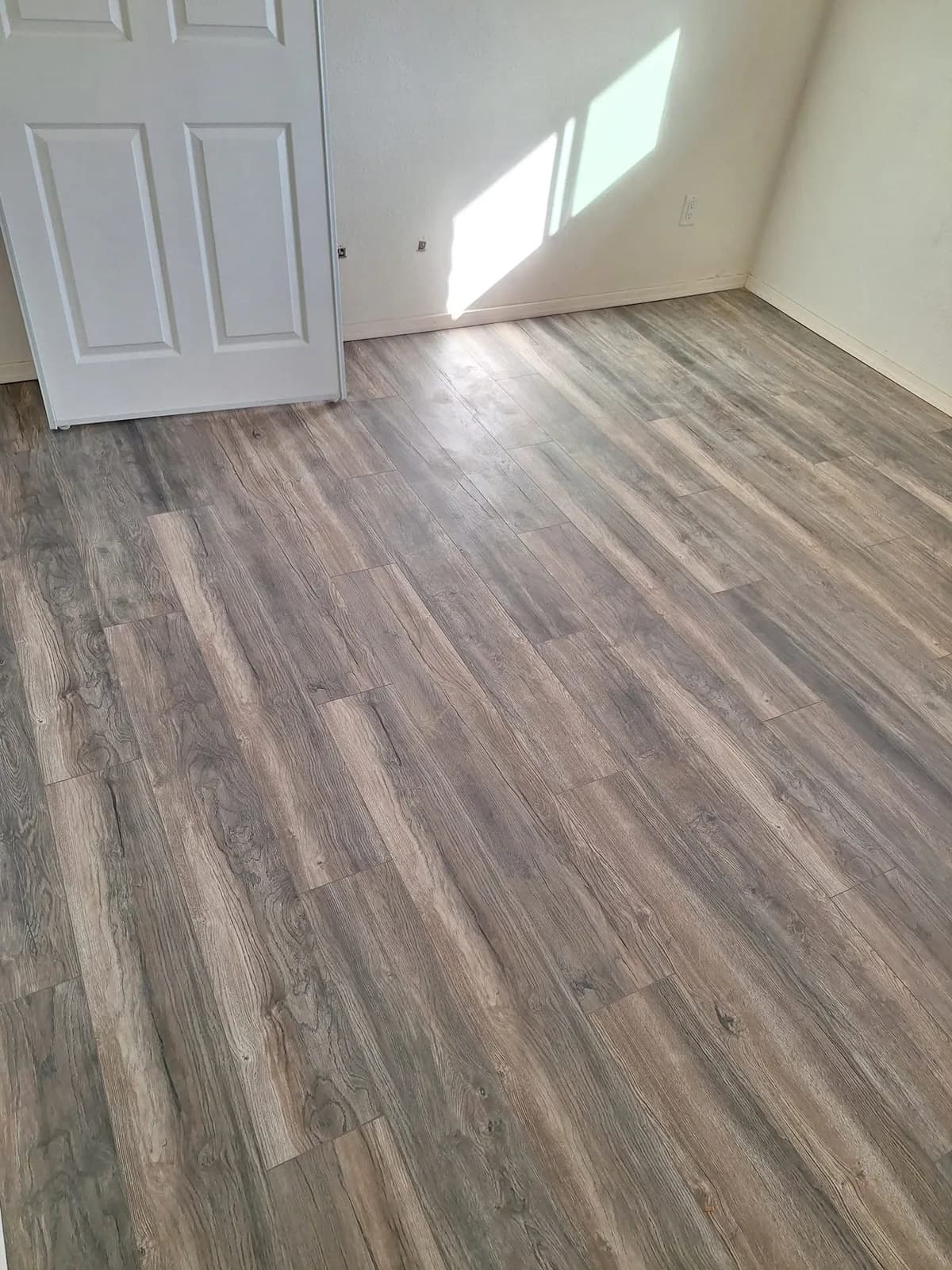 After: bedroom with finished wood-look plank flooring