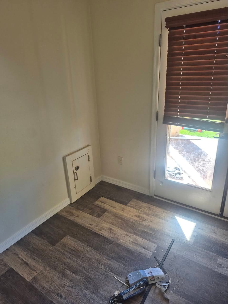 After: wood-look plank floor extending toward an exterior door