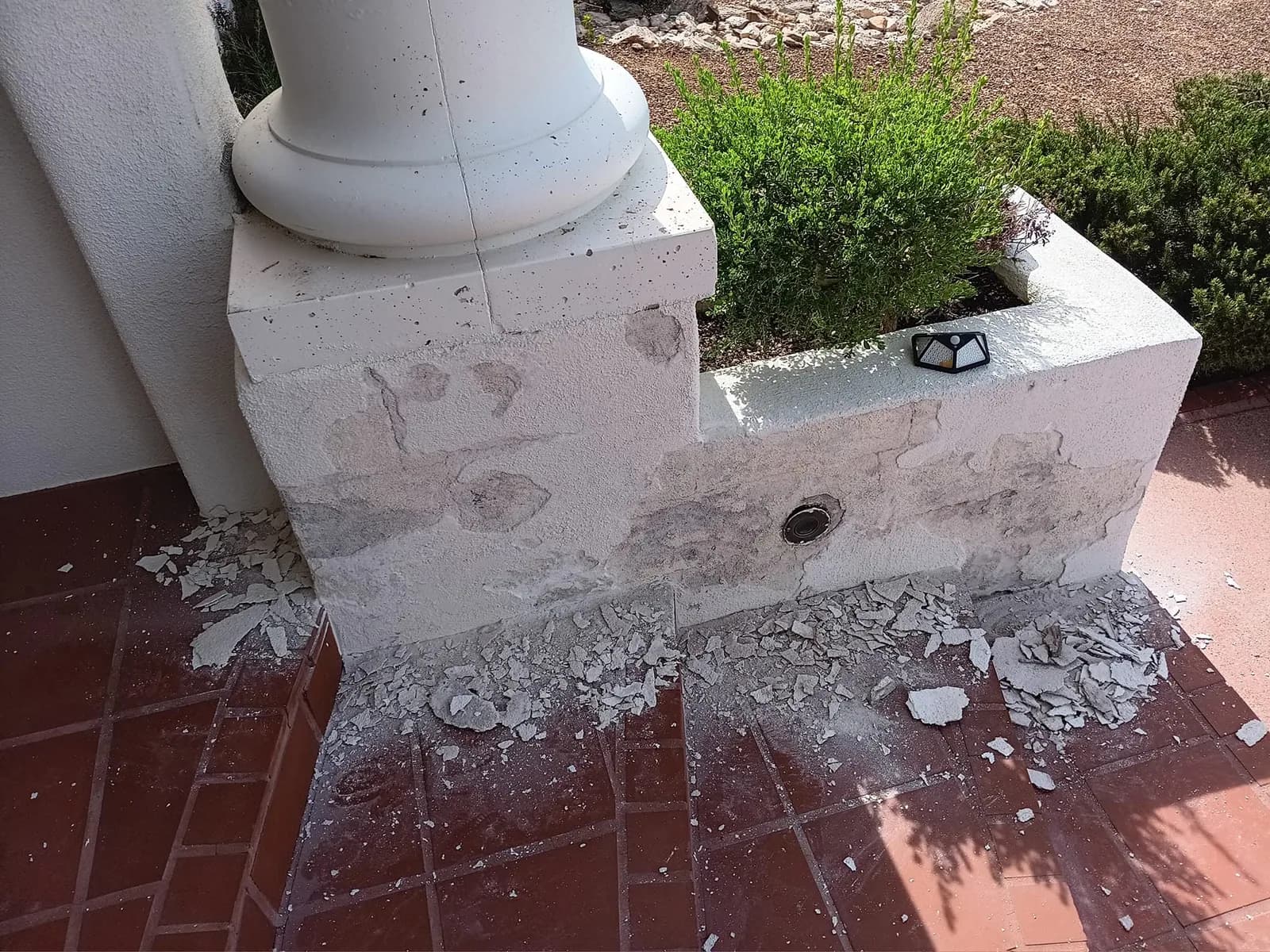 Before: deteriorated finish around the base of a residential entry wall