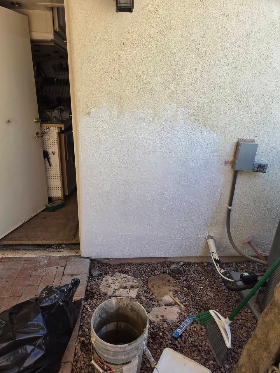 After: patched exterior wall opening with a light unfinished surface